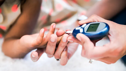 Close-up of a person using a blood glucose meter to check blood sugar levels with a finger prick test."